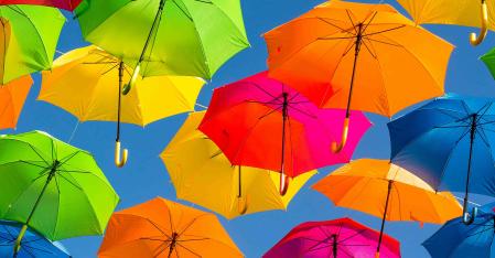 Paraguas de colores ante un cielo azul