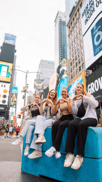 Grupo de aupairs sentadas en el time square en nueva york