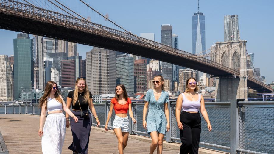 Grupo de cinco au pairs caminando cerca del puente de Brooklyn