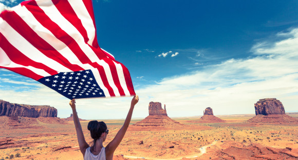 Au pair sosteniendo una bandera estadounidense en la mano