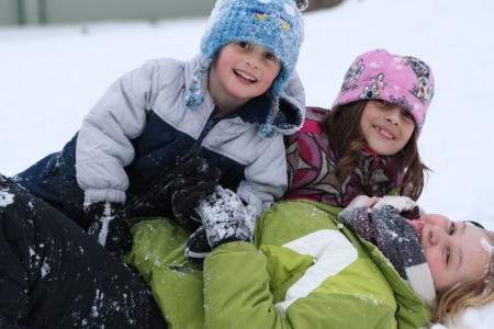 au pair jugando en la nieve con niños