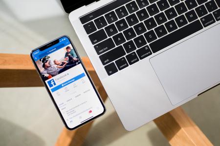 Móvil y ordenador portátil con la app de Facebook